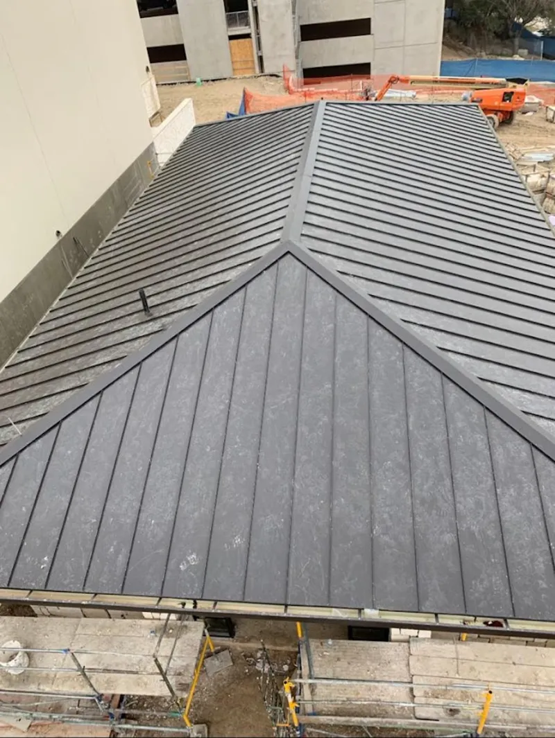 Commercial metal roof construction with crane equipment in Pompey